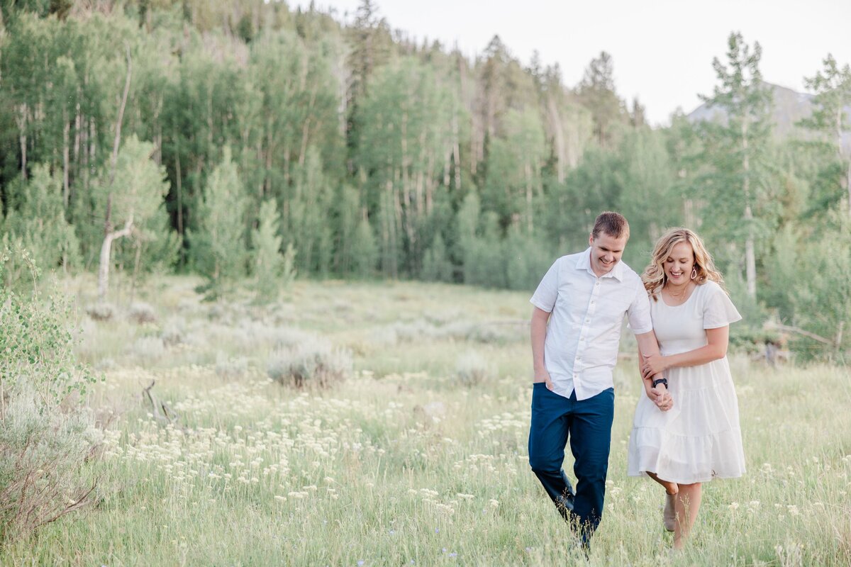 An image from a Breckenridge Couples Photographer of a happy couple on a mountain hike in white