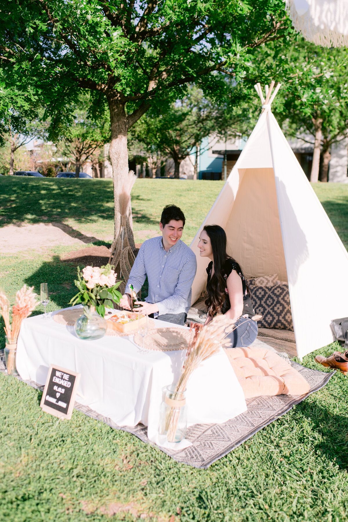 Proposal ideas in Austin couple sitting at picnic out side of tent
