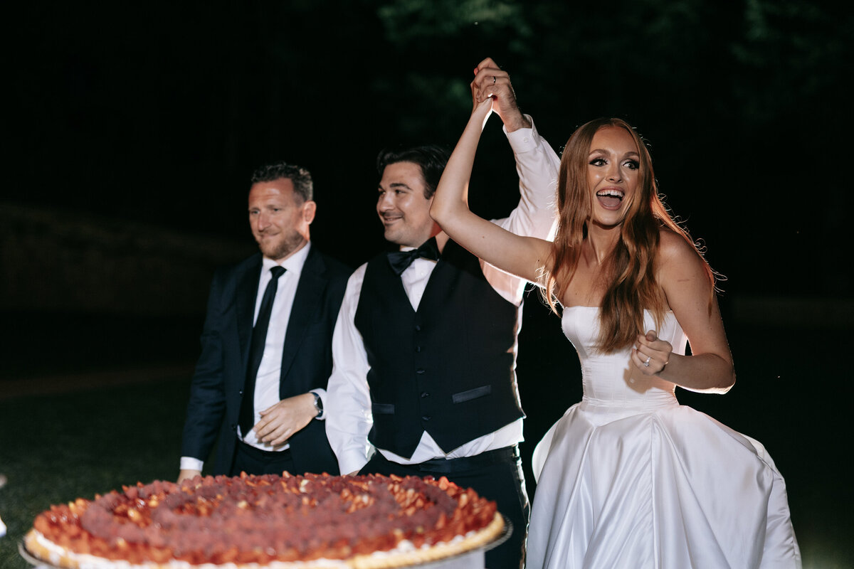 Bride and groom cutting  traditional Italian Wedding cake in Tuscany