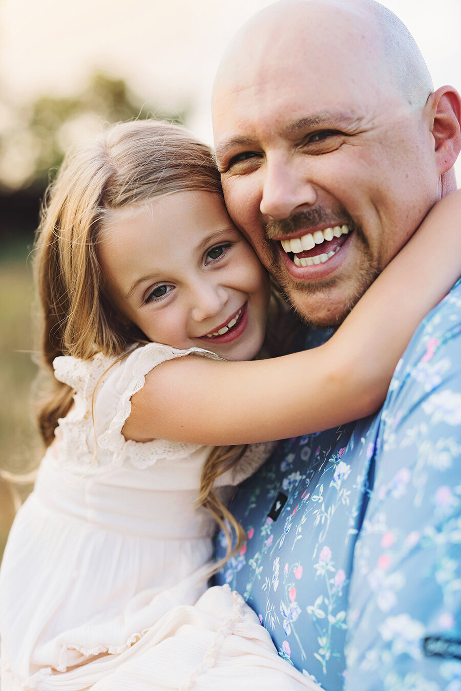 Dad and daughter snuggling and smiling with each other