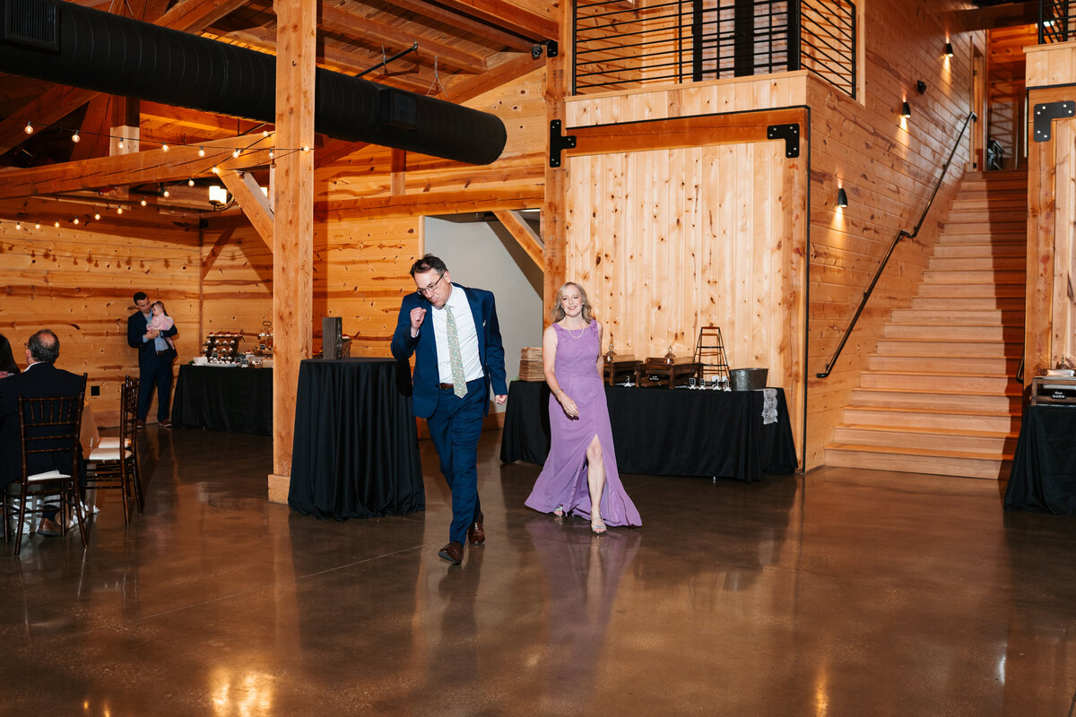 Elegant reception setup with candles, florals, and wooden tables