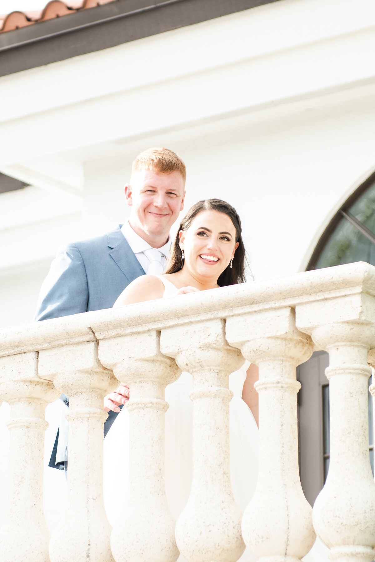 Bride and groom standing on balcony