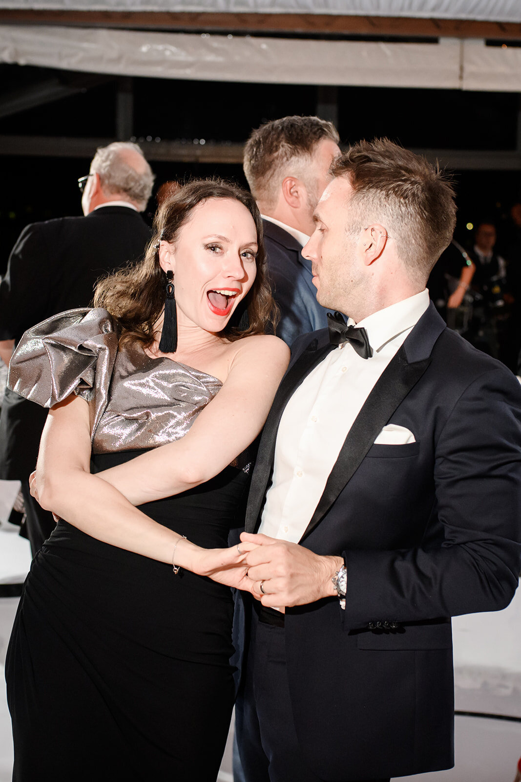 Guests laughing and dancing at the reception, filled with excitement.