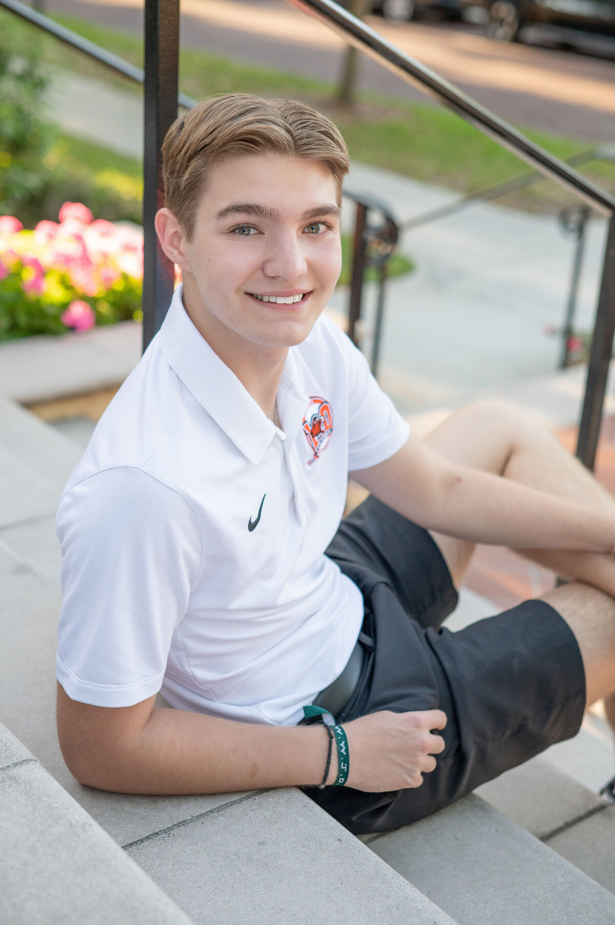 High school senior boy leaning against stone stairs by Khim Higgins Photography.