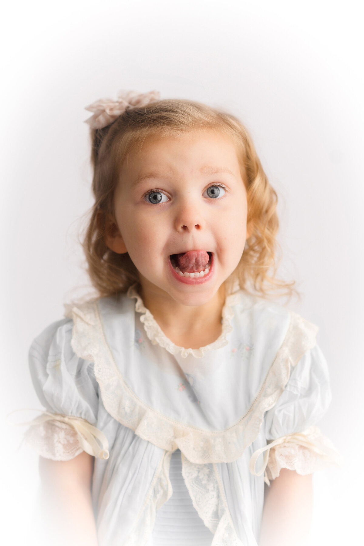 Little girl makes a silly face at the camera during her Heirloom Portrait Session in Charleston, SC.