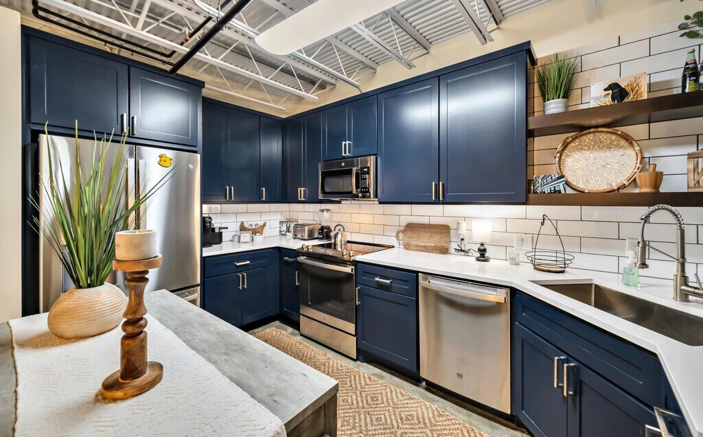 Fully stocked kitchen with stainless steel appliances in this 2 bedroom, 2.5 bathroom luxury vacation rental loft condo for 8 guests with incredible downtown views, free parking, free wifi and professional decor in downtown Waco, TX.