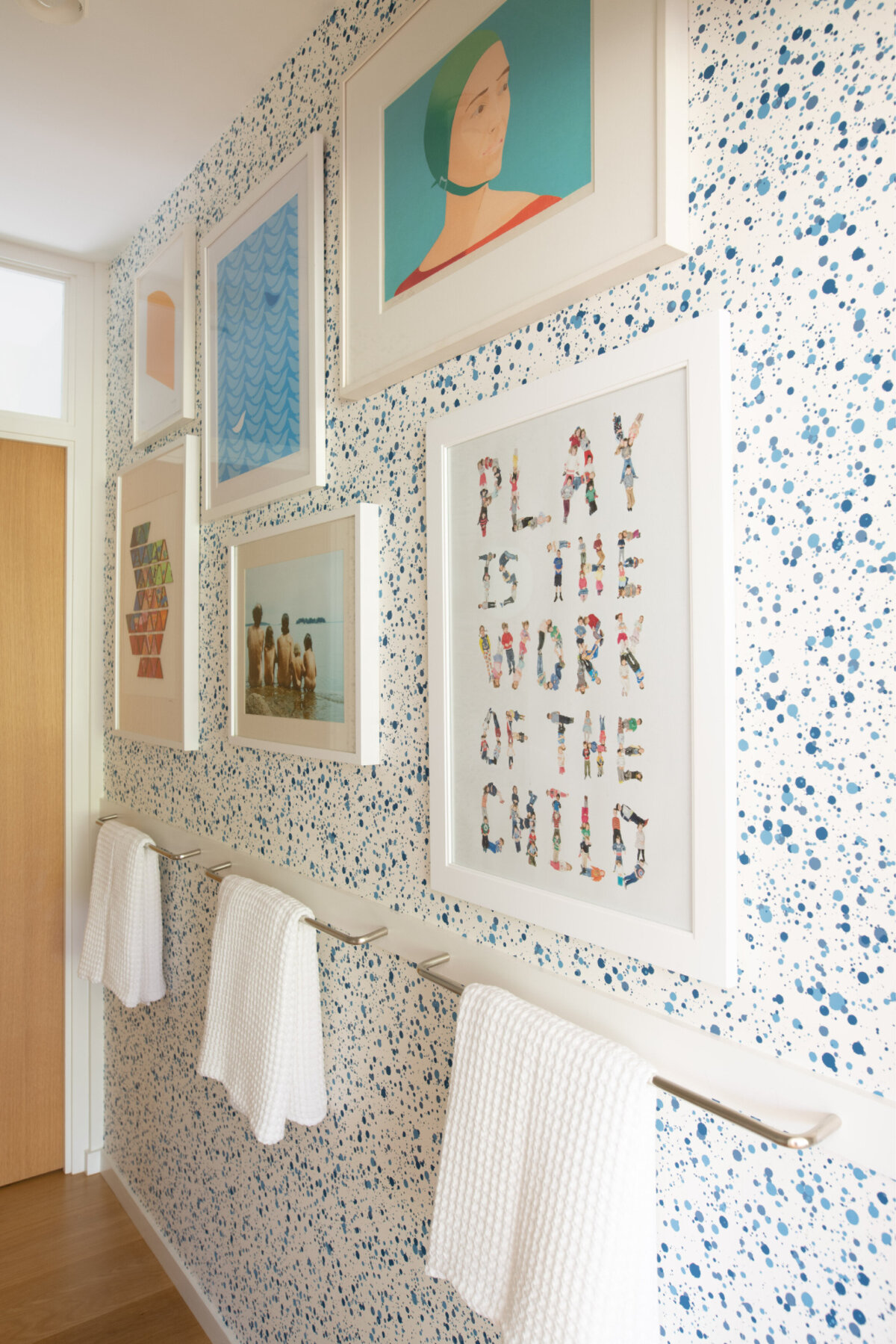 Playful art against 70s Hinson paint splatter wallpaper creates a whimsical vibe in the kids' bath of this Main Street Hingham home. As seen in Boston Globe magazine.