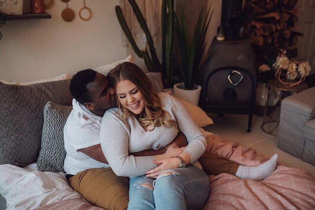 Husband and wife giggling during a natural light studio photoshoot