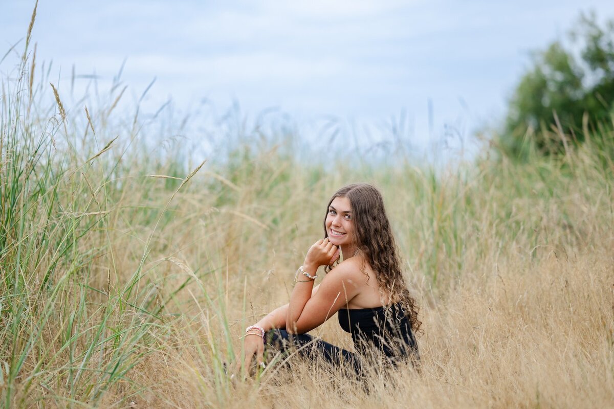 seattle senior girl sitting in tall grass