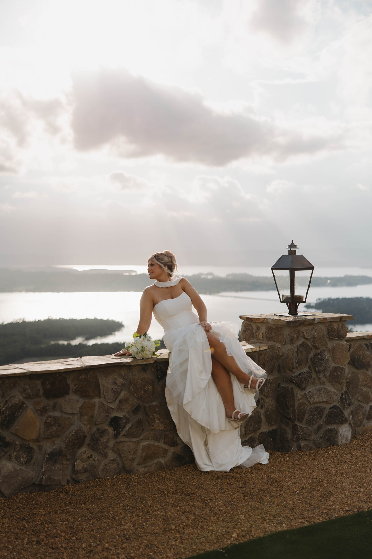 Bride sitting on stone edge at Stone Haven Wedding Venue