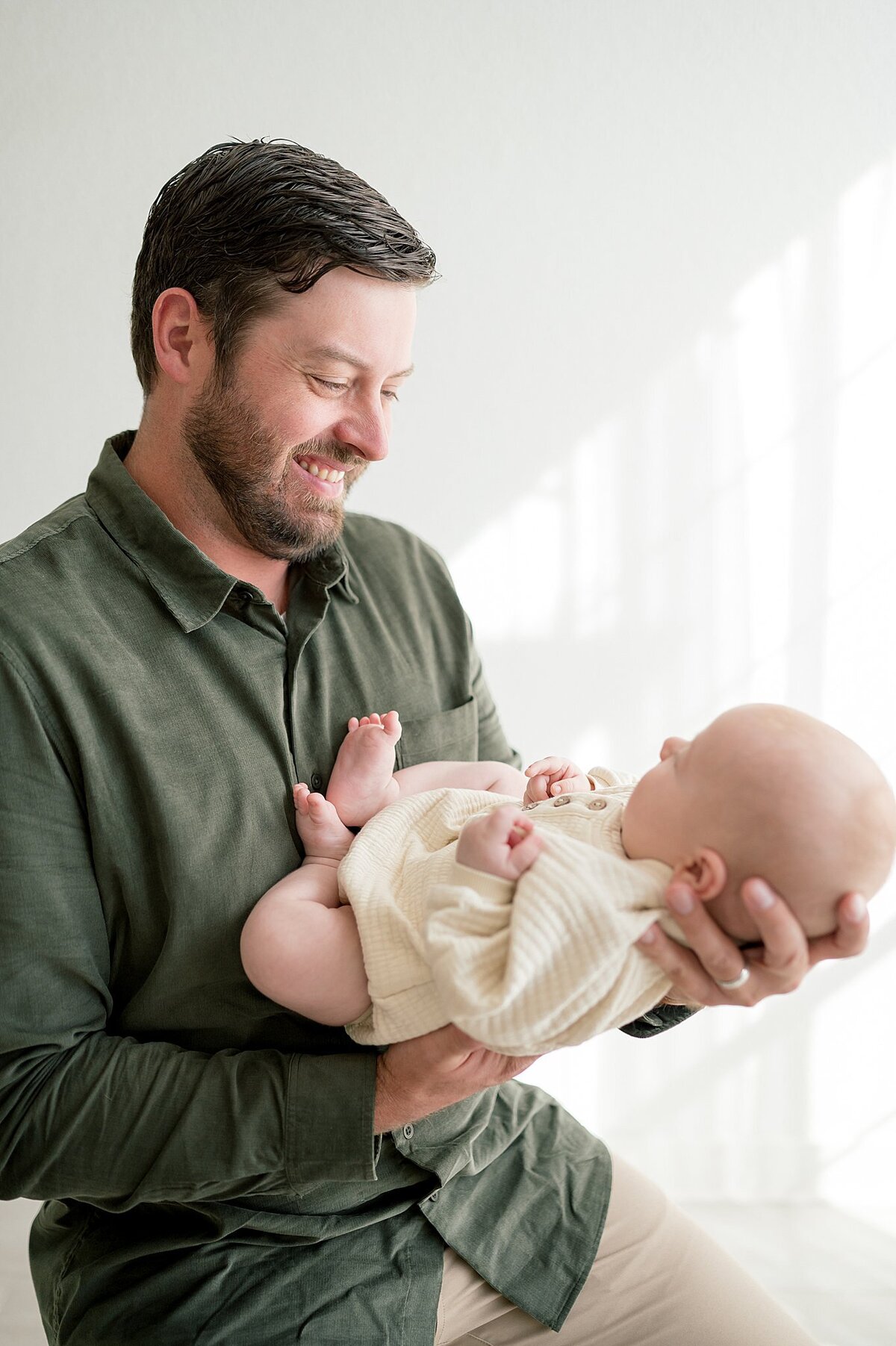Dad holding baby during a dallas newborn photography photoshoot