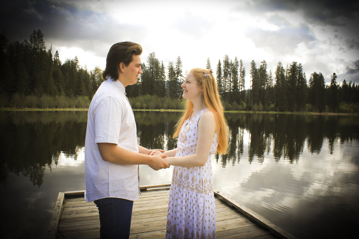 Newly Engaged Couple holding hands near lake