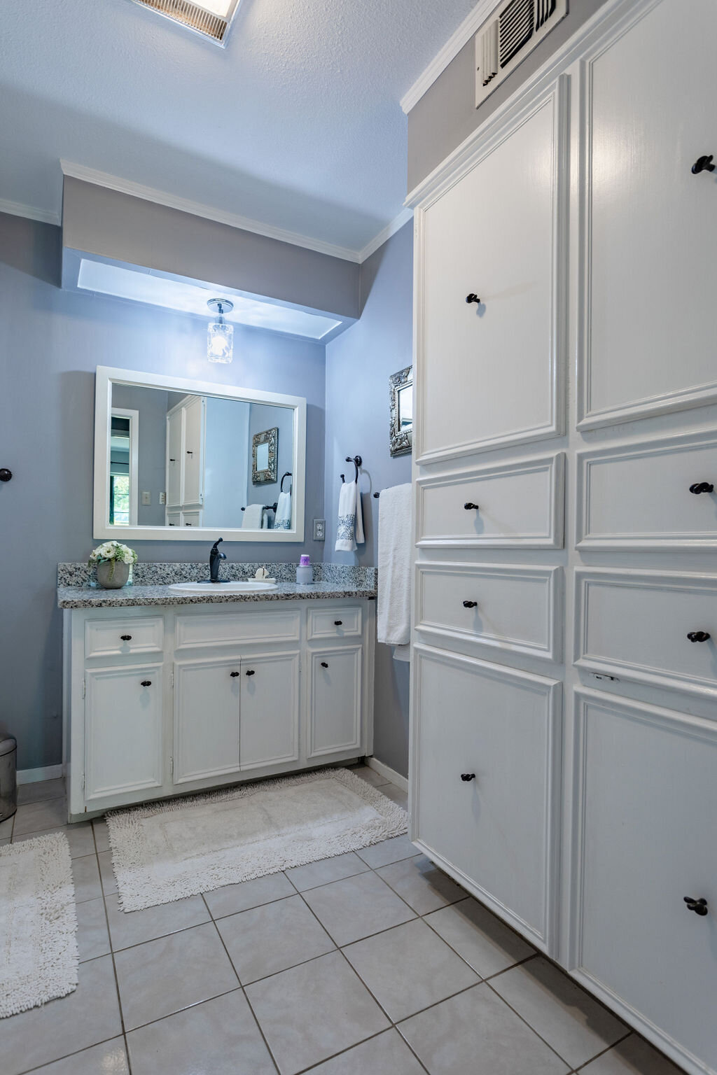 Bathroom with large single vanity and plenty of storage space in this 5-bedroom, 4-bathroom vacation rental house for 16+ guests with pool, free wifi, guesthouse and game room just 20 minutes away from downtown Waco, TX.