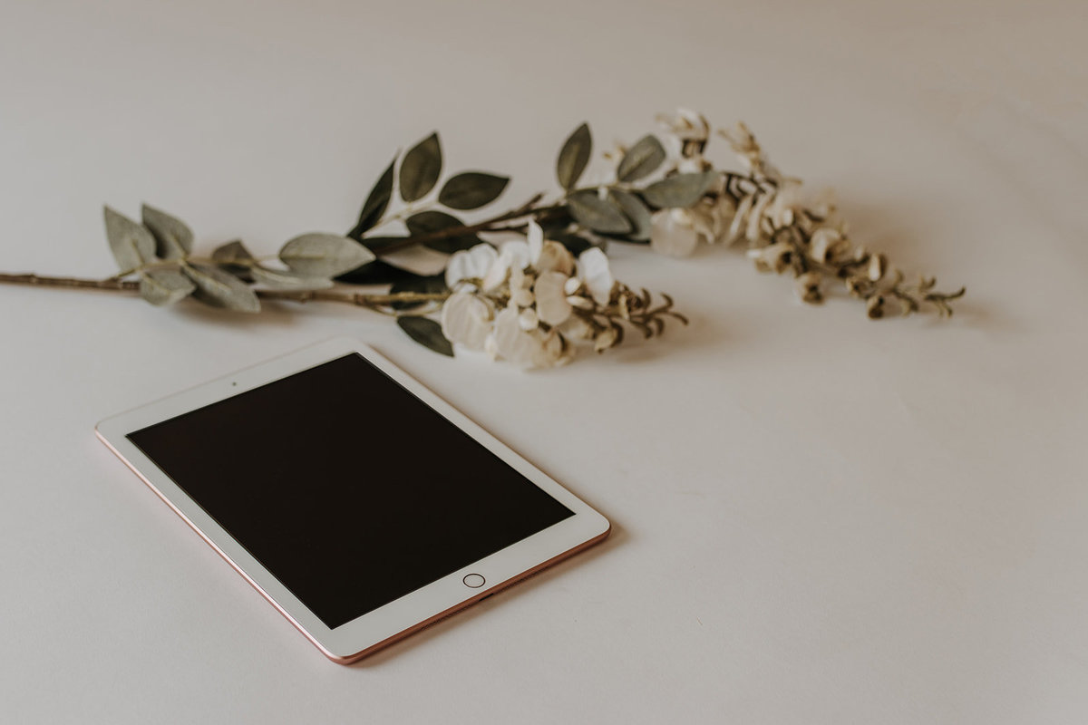 Blank Ipad with white flowers on white backdrop