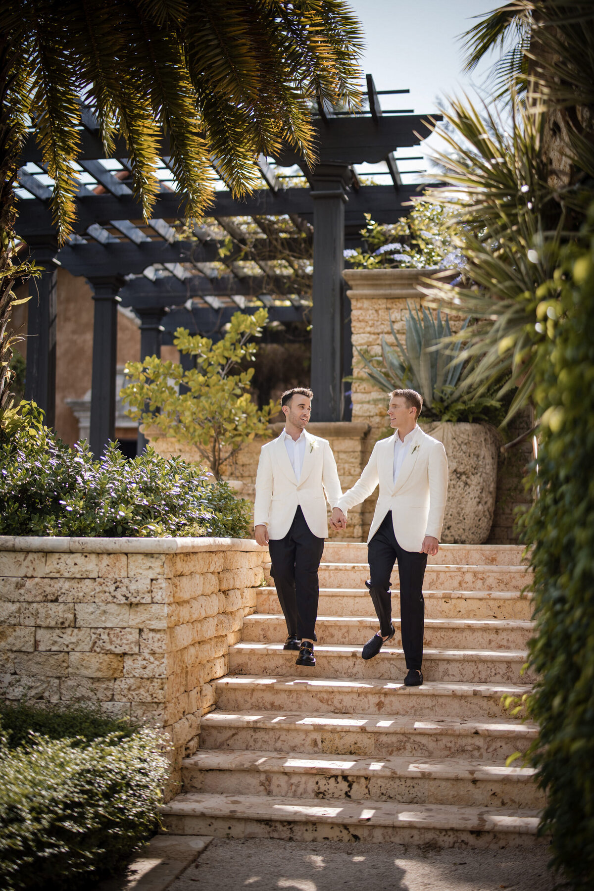 Two groom walk down stairs  at a destination wedding in Puerto Rico