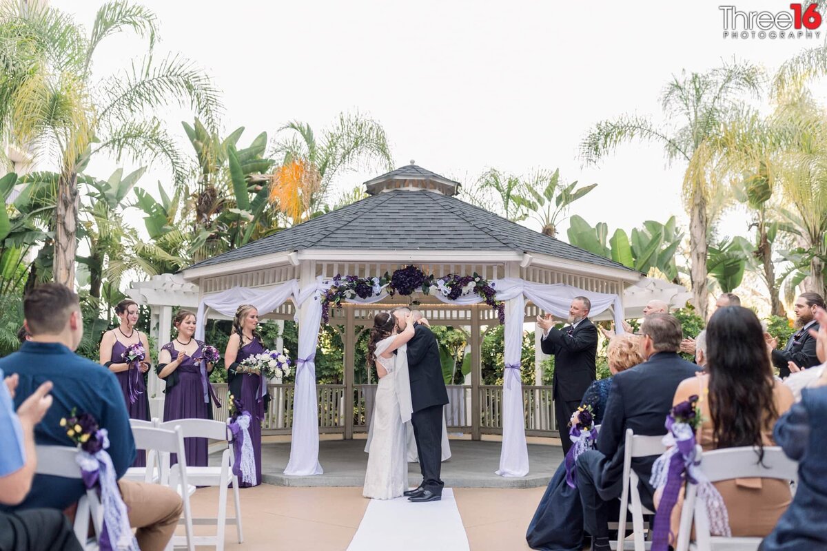 Bride and Groom share their first kiss as the guests cheer