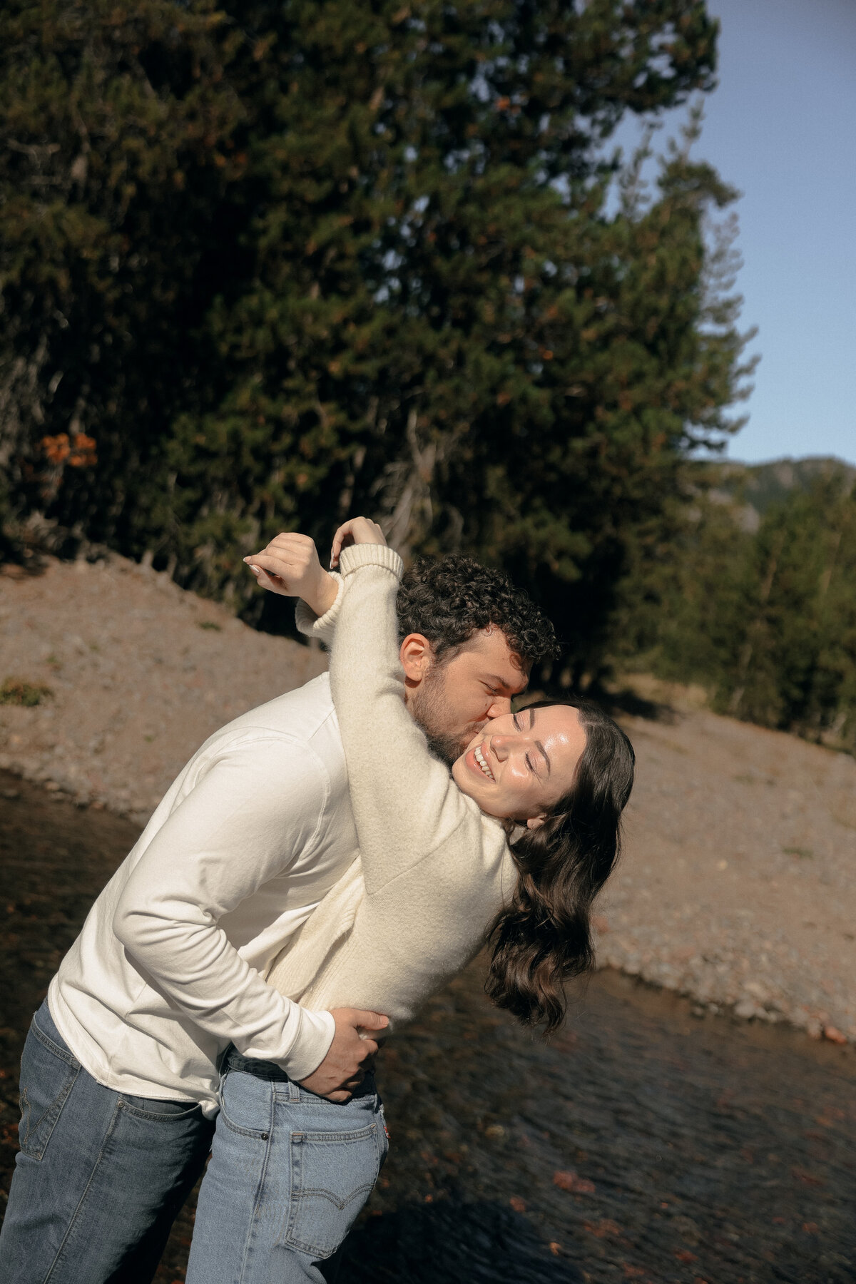 Black and White Portrait of Photographer Laughing by the Water’s Edge