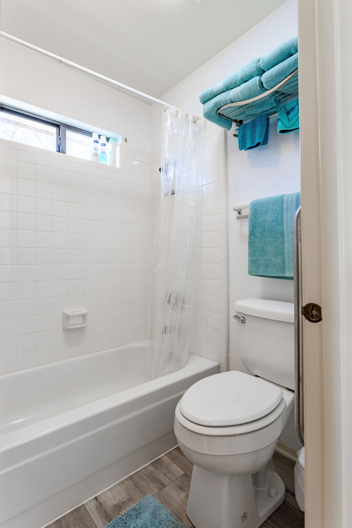 Bathroom with shower and bathtub in this 2-bedroom, 2-bathroom lakeside vacation rental home for 6 guests on Tradinghouse Lake with privacy access to a fishing dock and boat launch pad, ping pong table, gazebo, free wifi and free parking in Waco, TX.