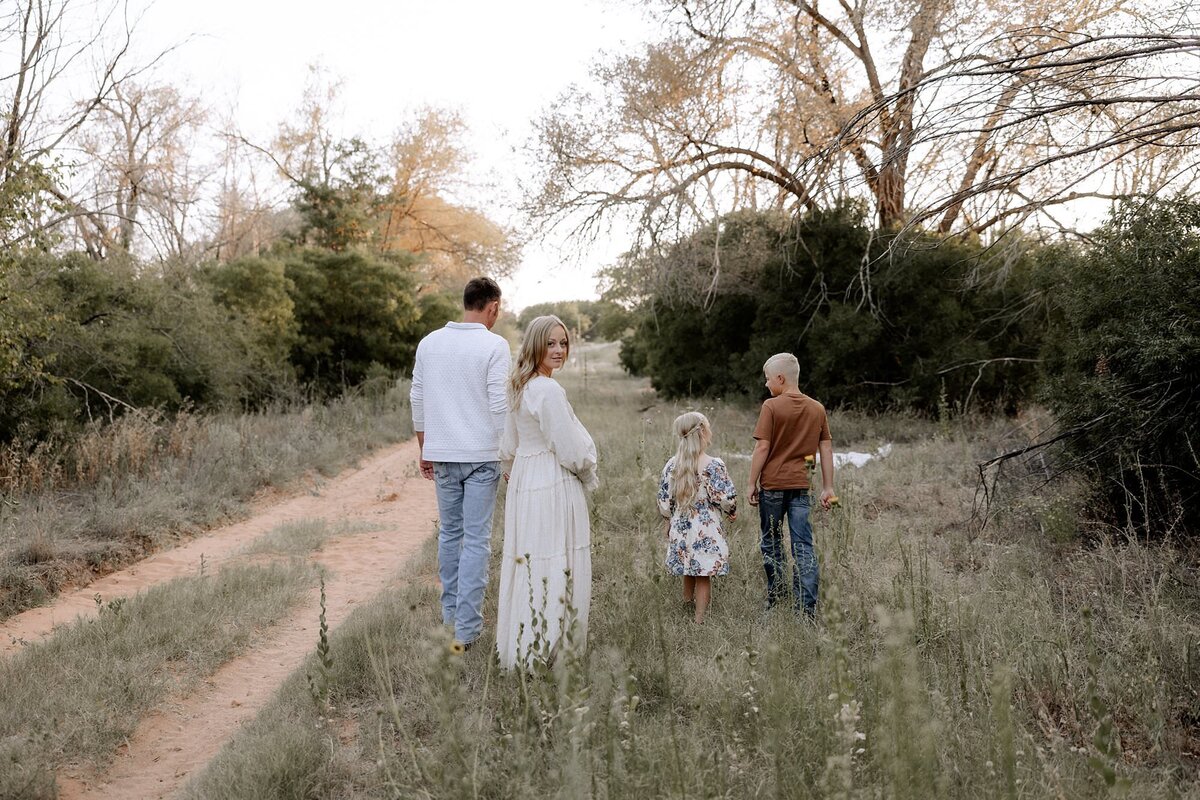 family of four walking beside a pathway, mama expecting a baby girl