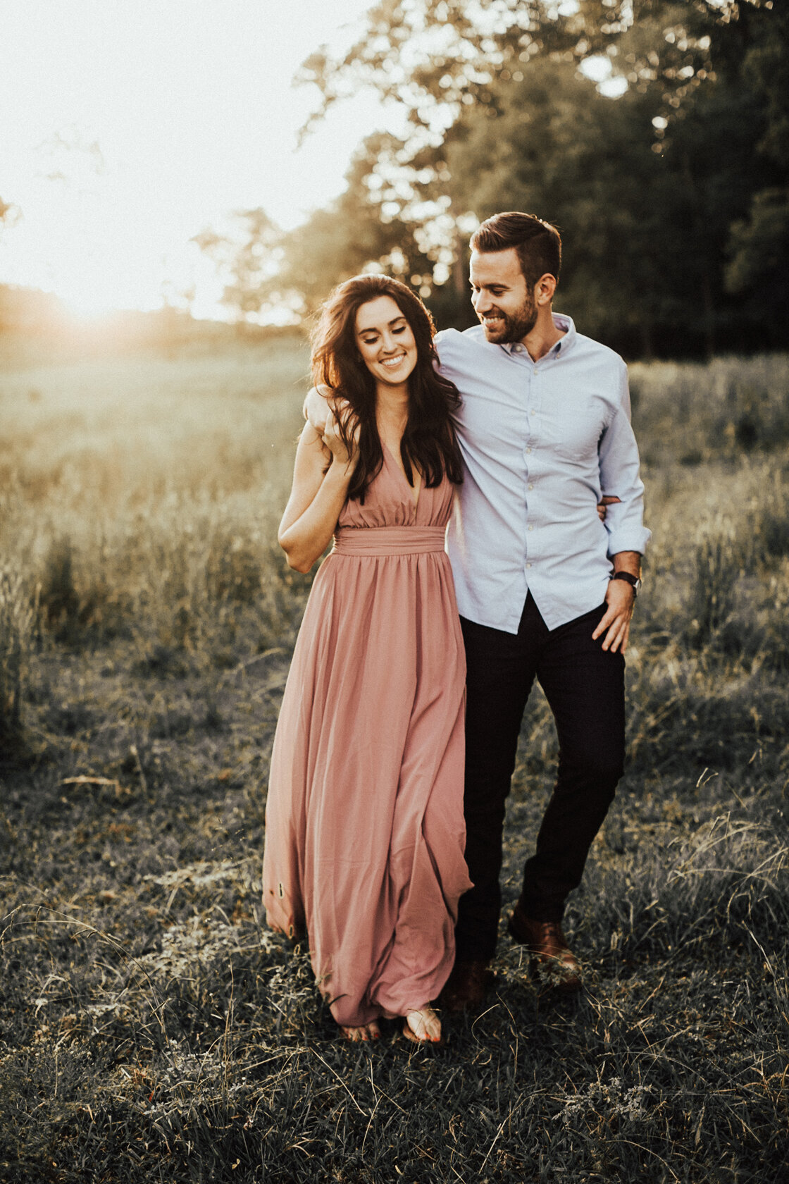 couple walking together at sunset  smiling at each other