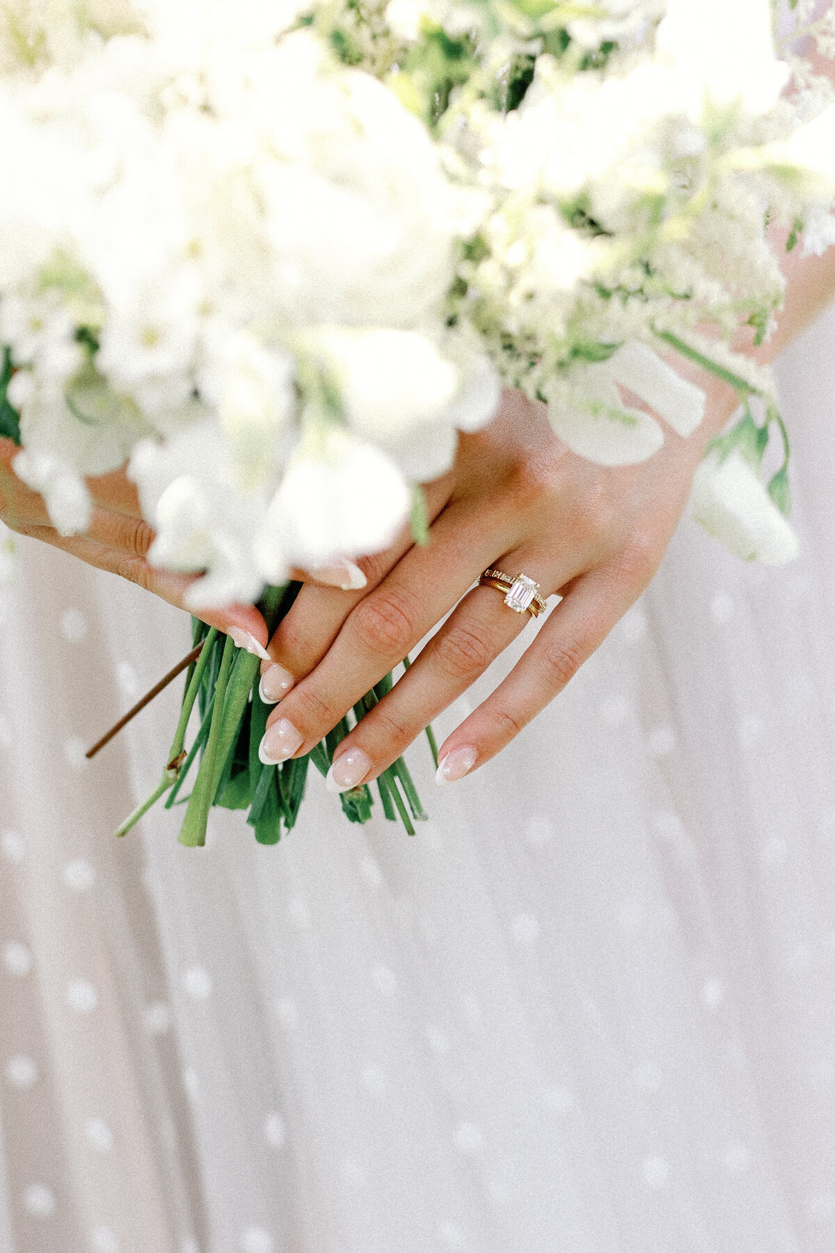 Bride holds petite white bouquet and Swiss dot whimiscal dress with pearl nails