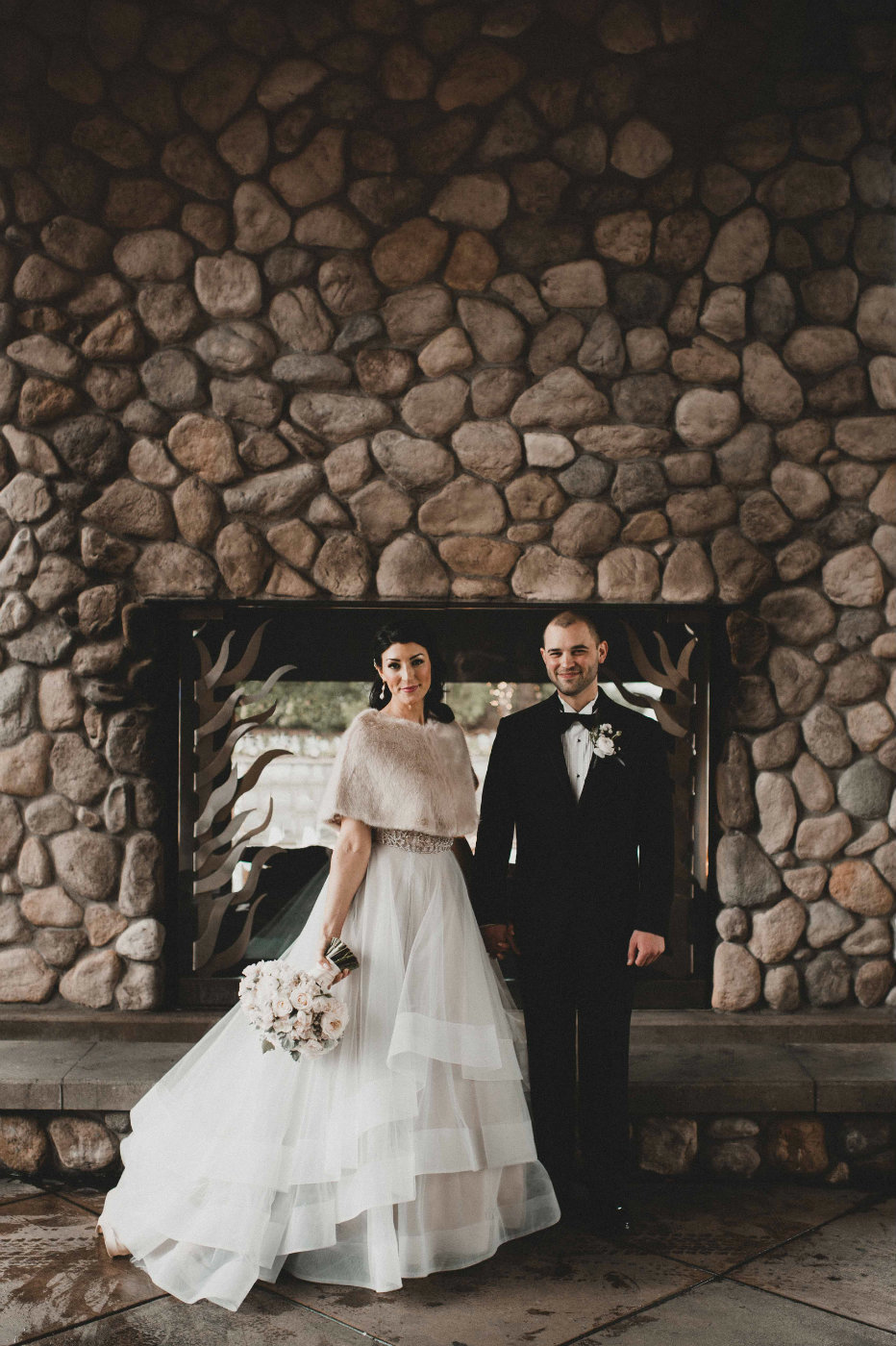 bride and groom at their winter wedding at Edgewater Hotel Seattle in front of large stone walled fireplace