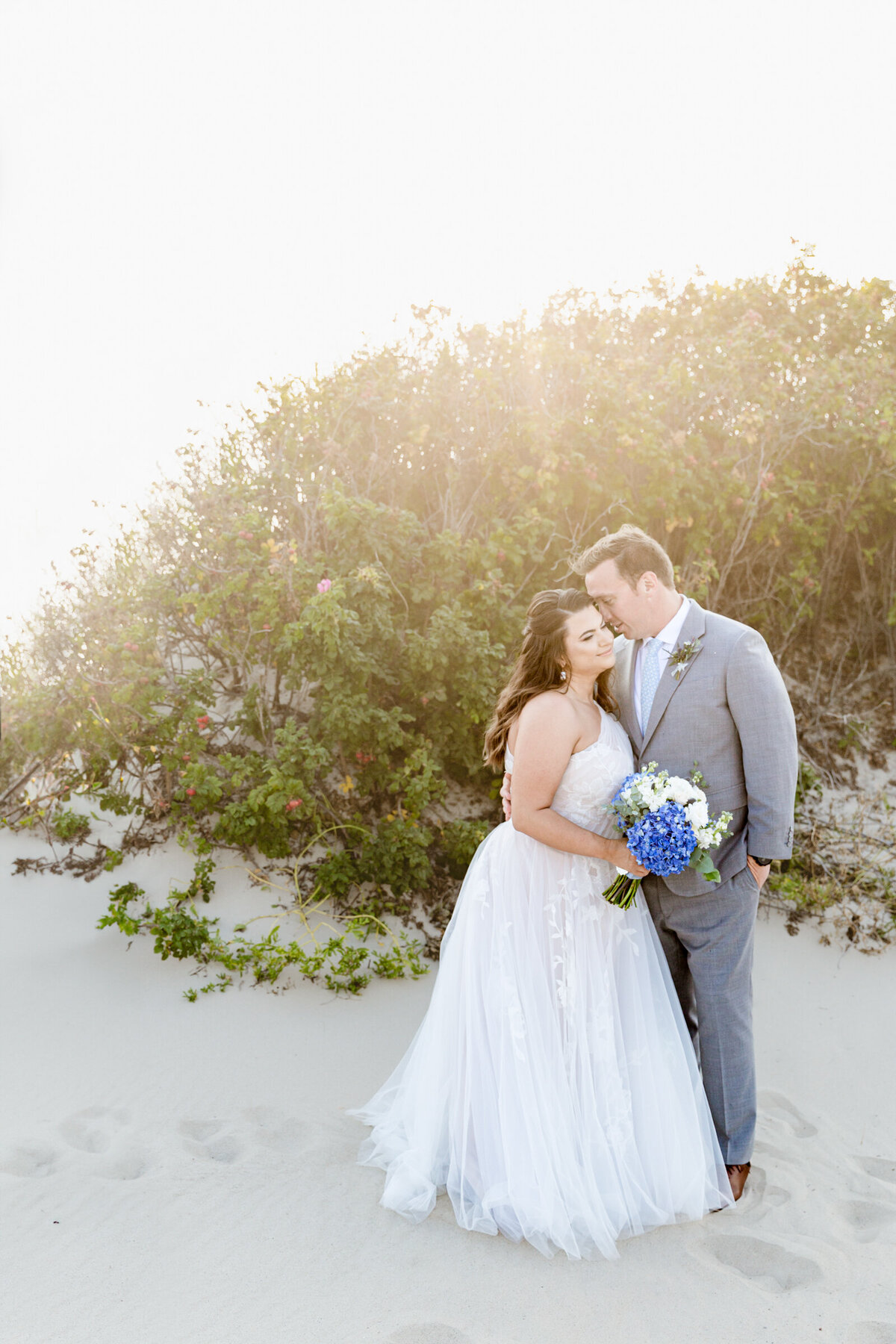 A bride in a flowy romantic dress and a groom in a light gray suit