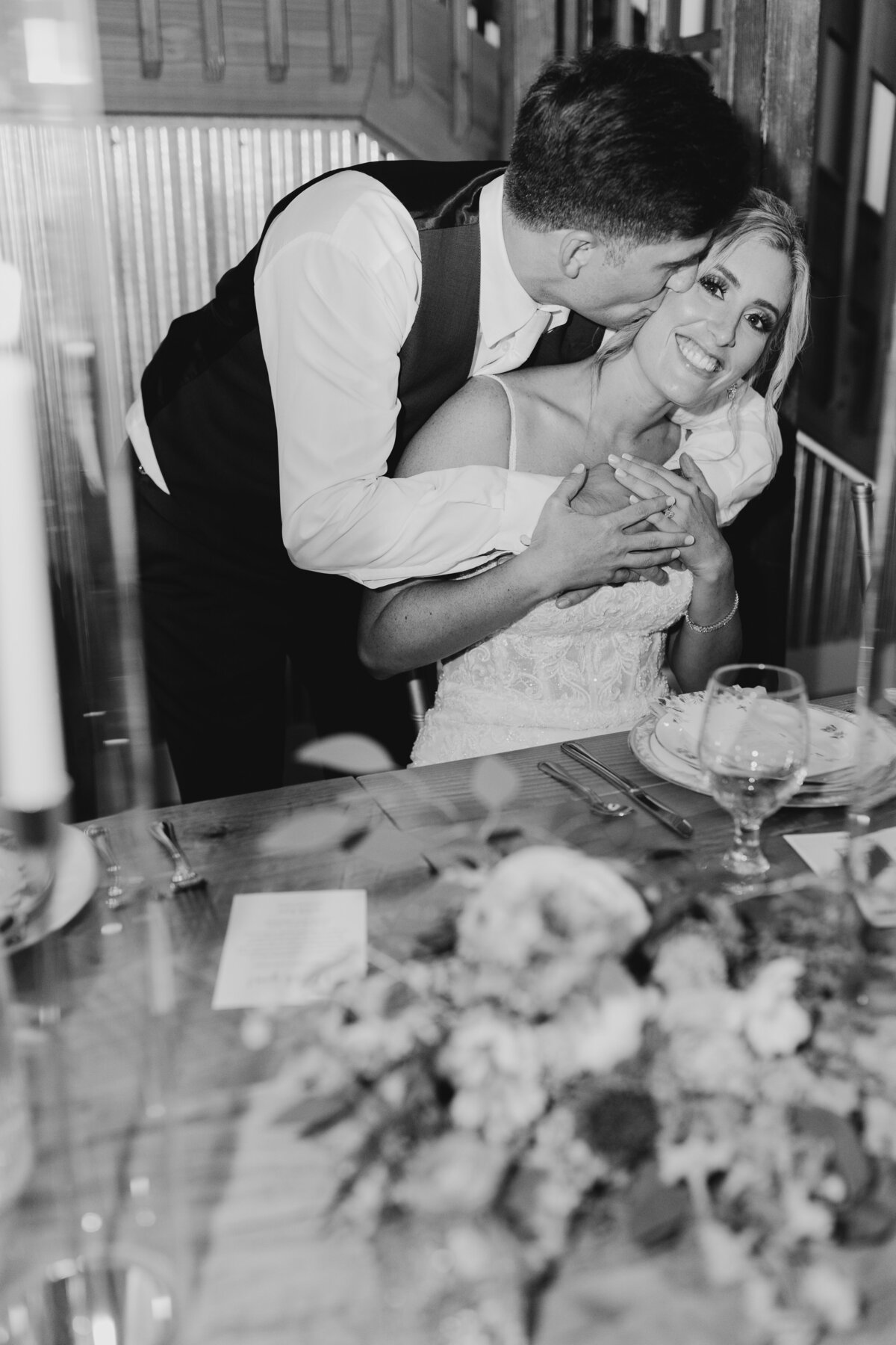 Bride and groom laughing together during a wedding reception dinner in South Bend.