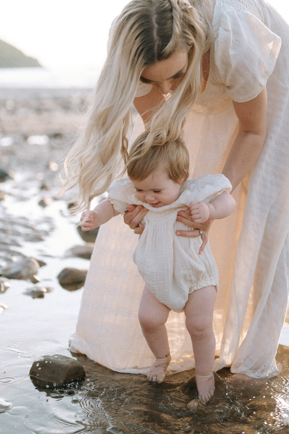 Family photography of a mother by the beach with her baby