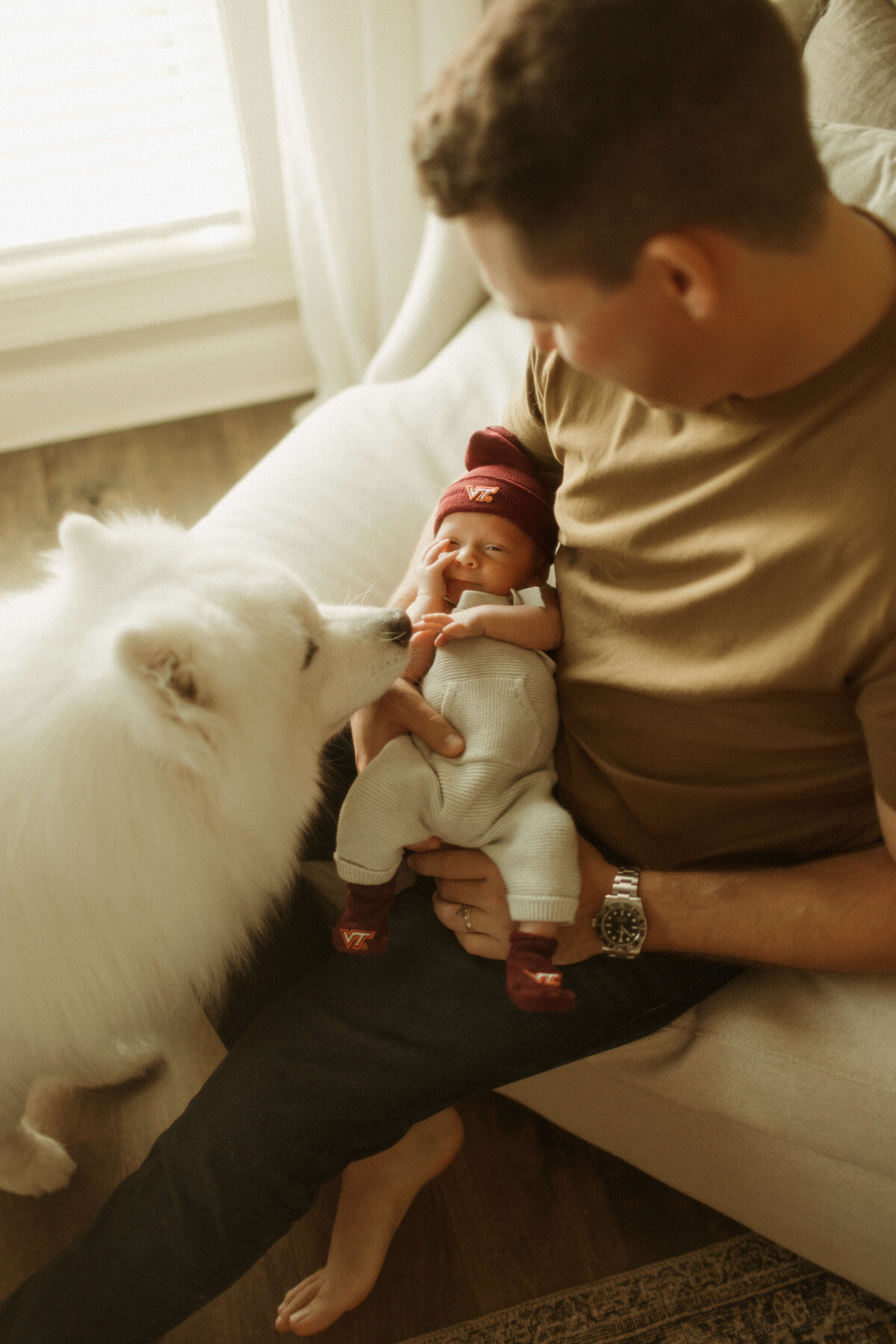 Natural light newborn photo in Franklin TN home with baby resting on bed with dog