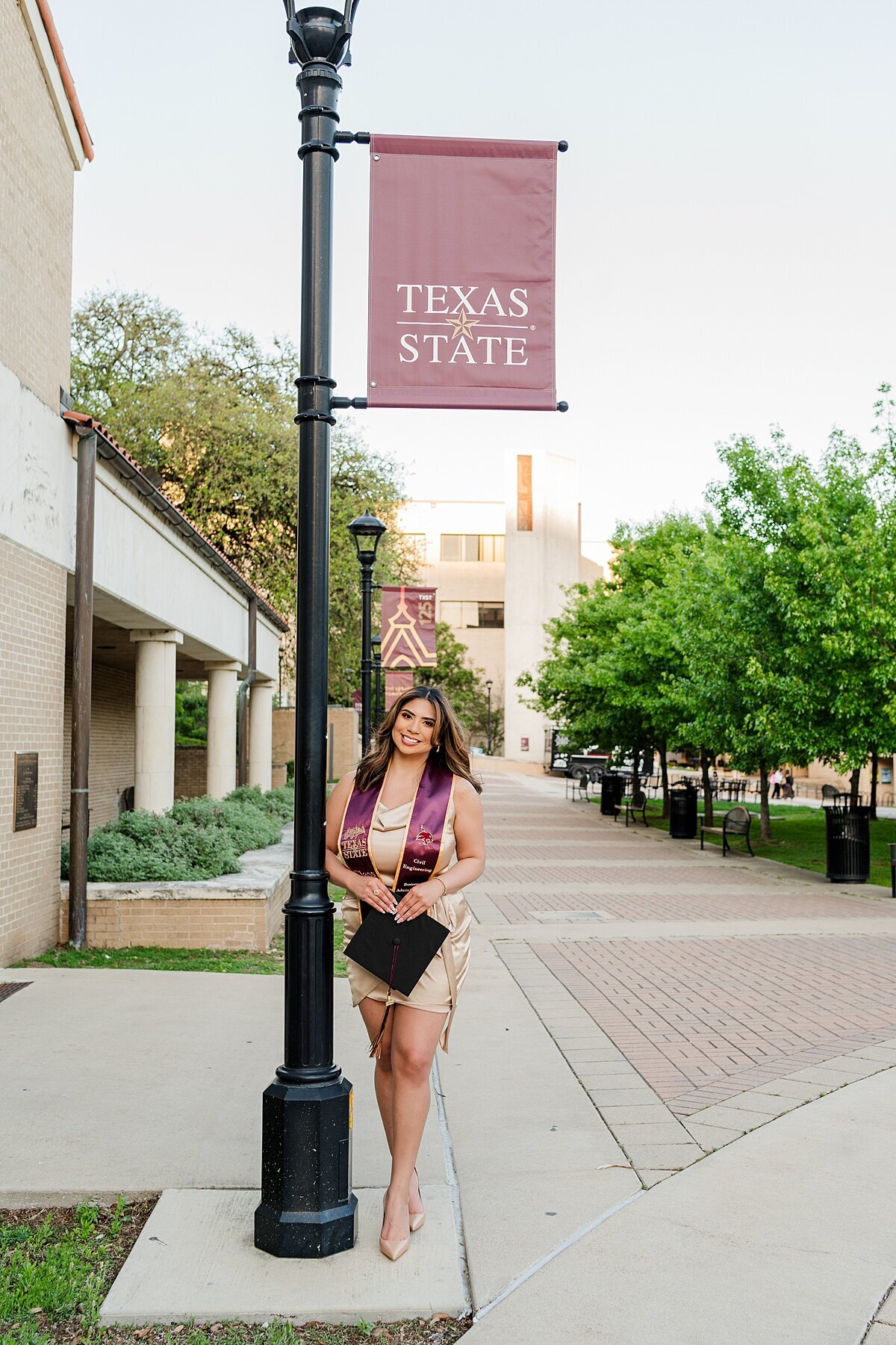 Texas state grad photos by pole near the fountain 