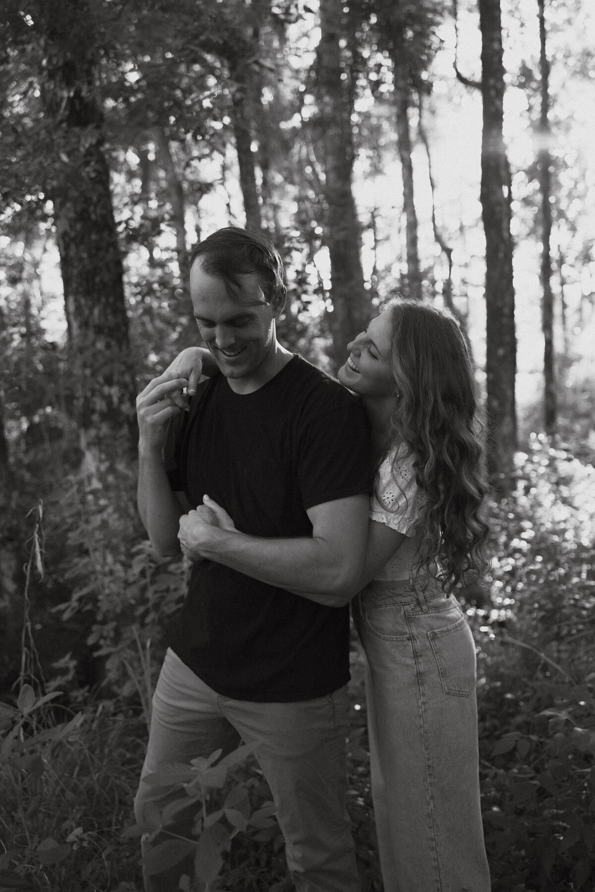 Couple posing for portraits in a forest.