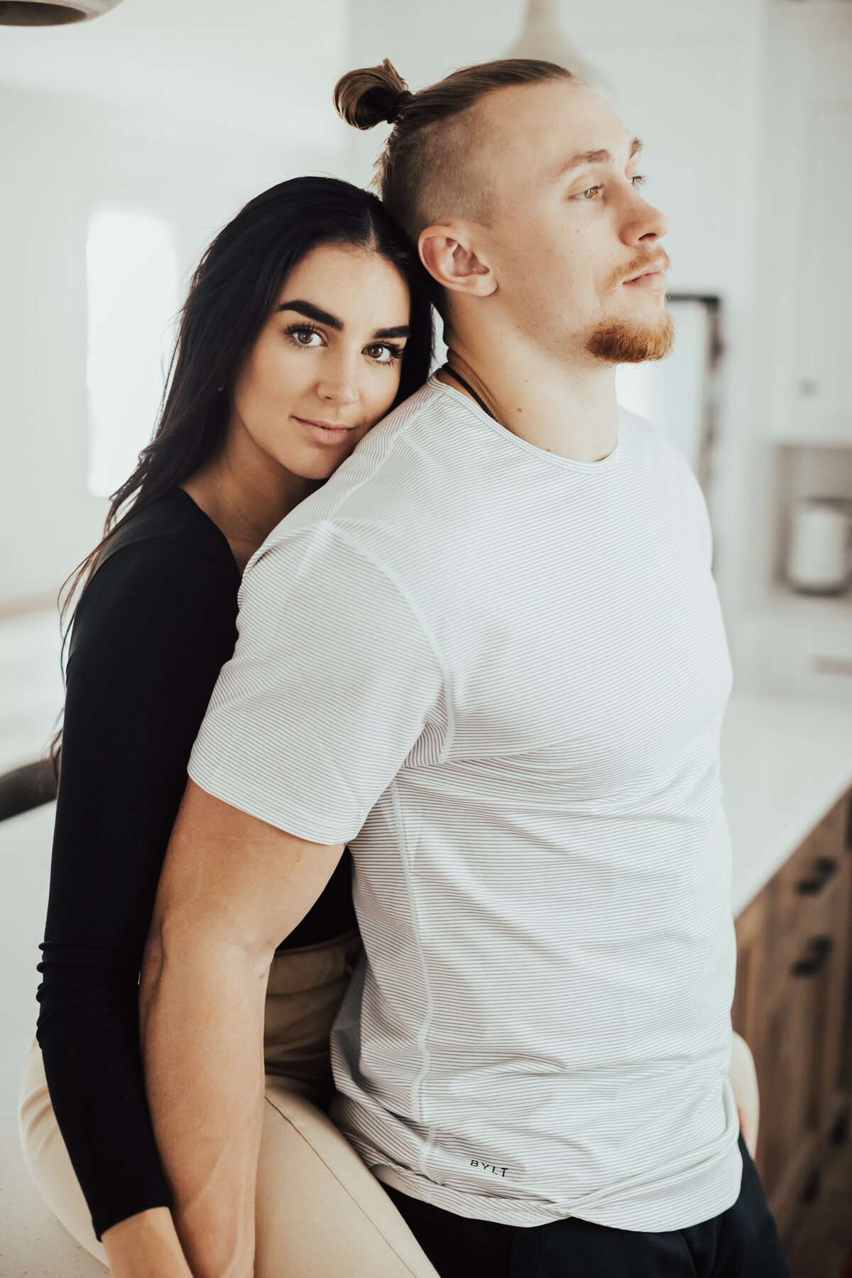 couple snuggling in kitchen on counter in home, George Kittle and Claire Kittle