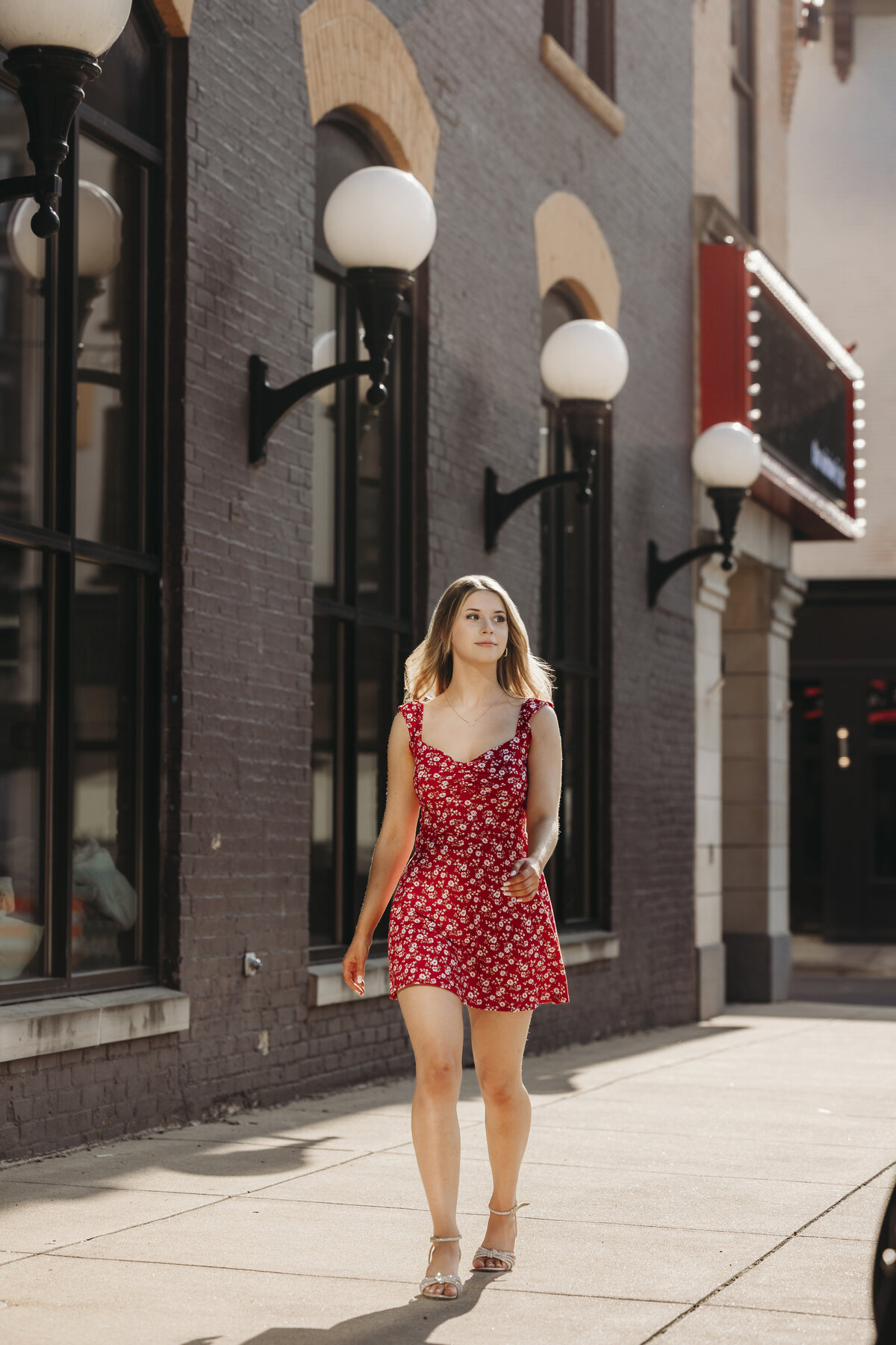 Senior girl walking next to the Civic Theater. 