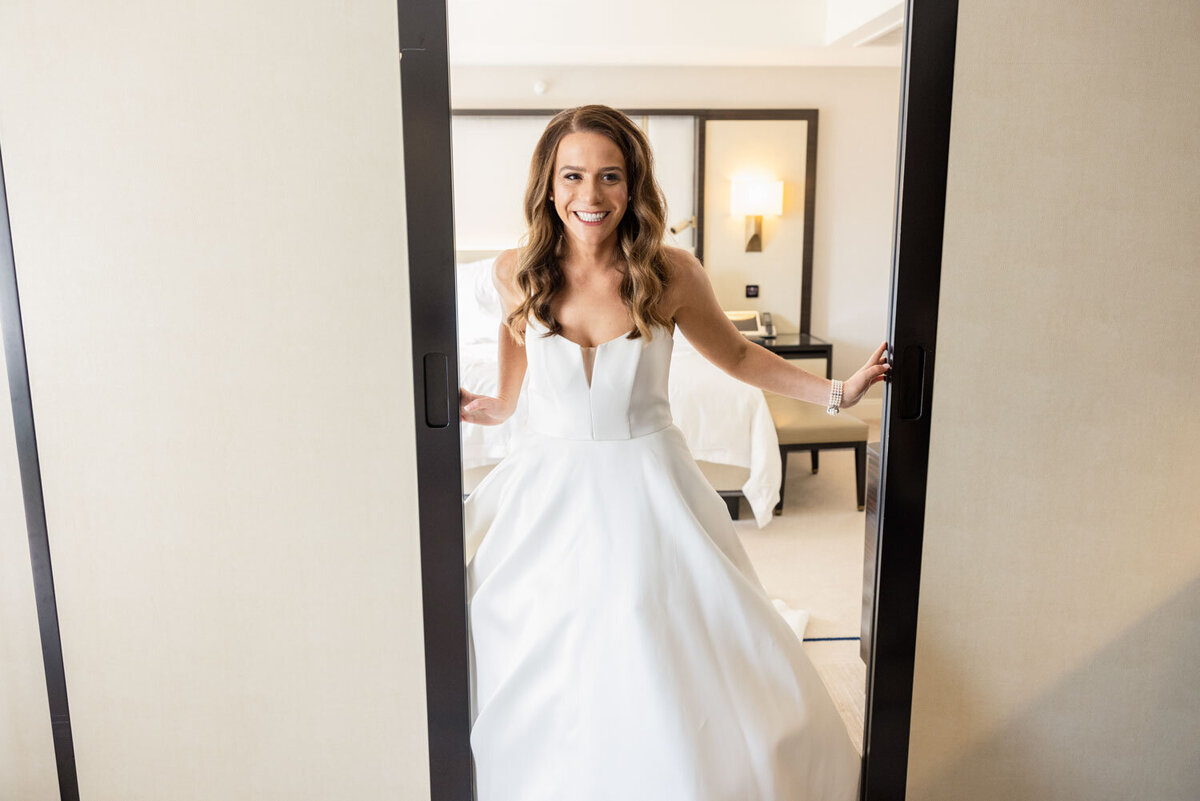 A woman in a white dress is standing in front of a mirror