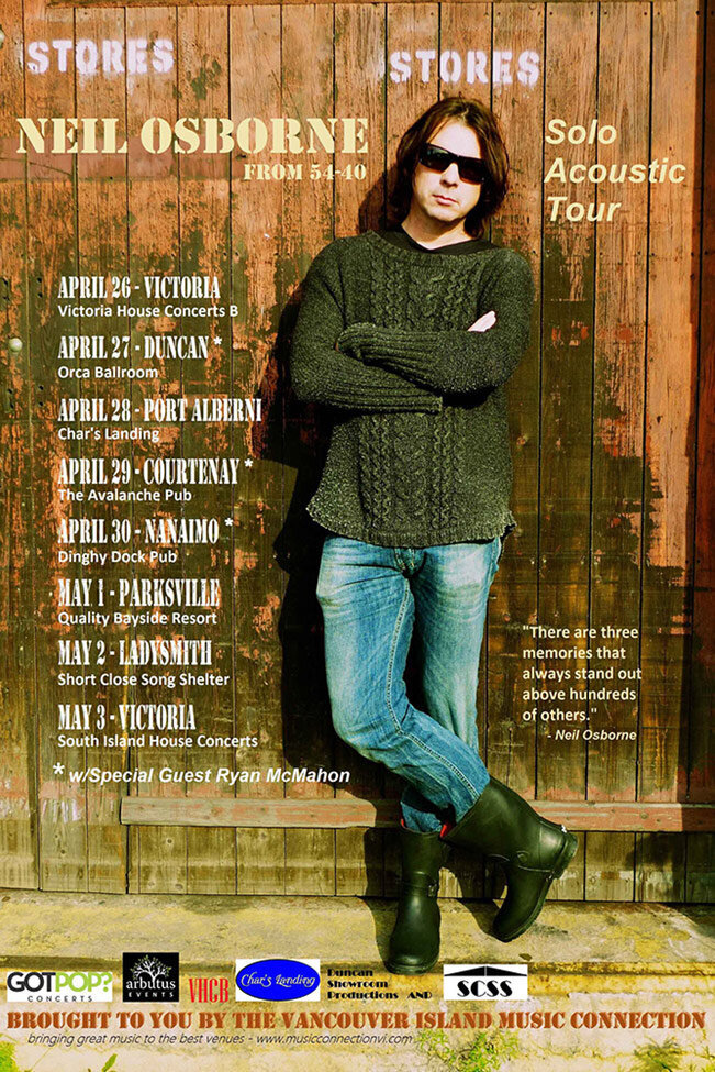 Tour Poster Artist Neil Osborne standing against weathered wood wall arms and legs crossed
