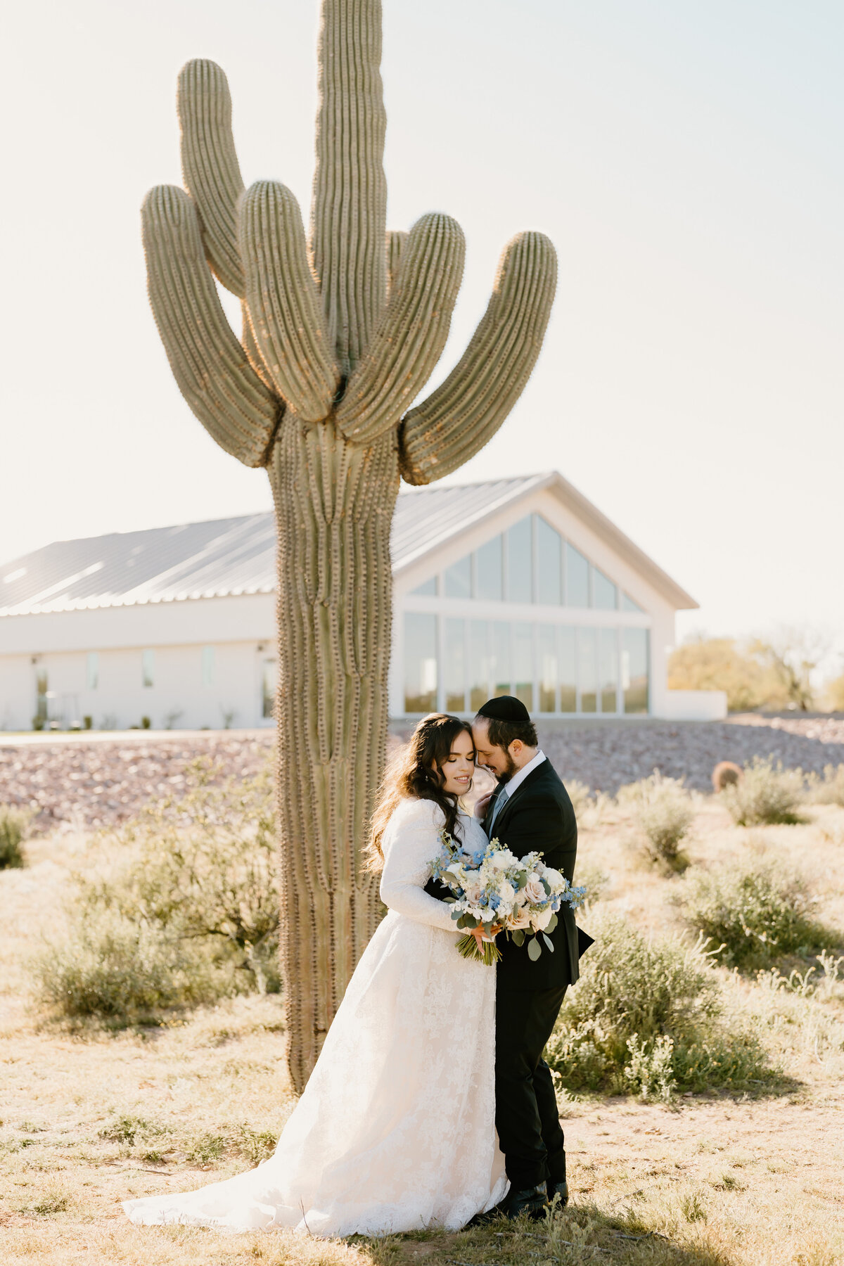 bride & groom in front of a cactus in the desert
