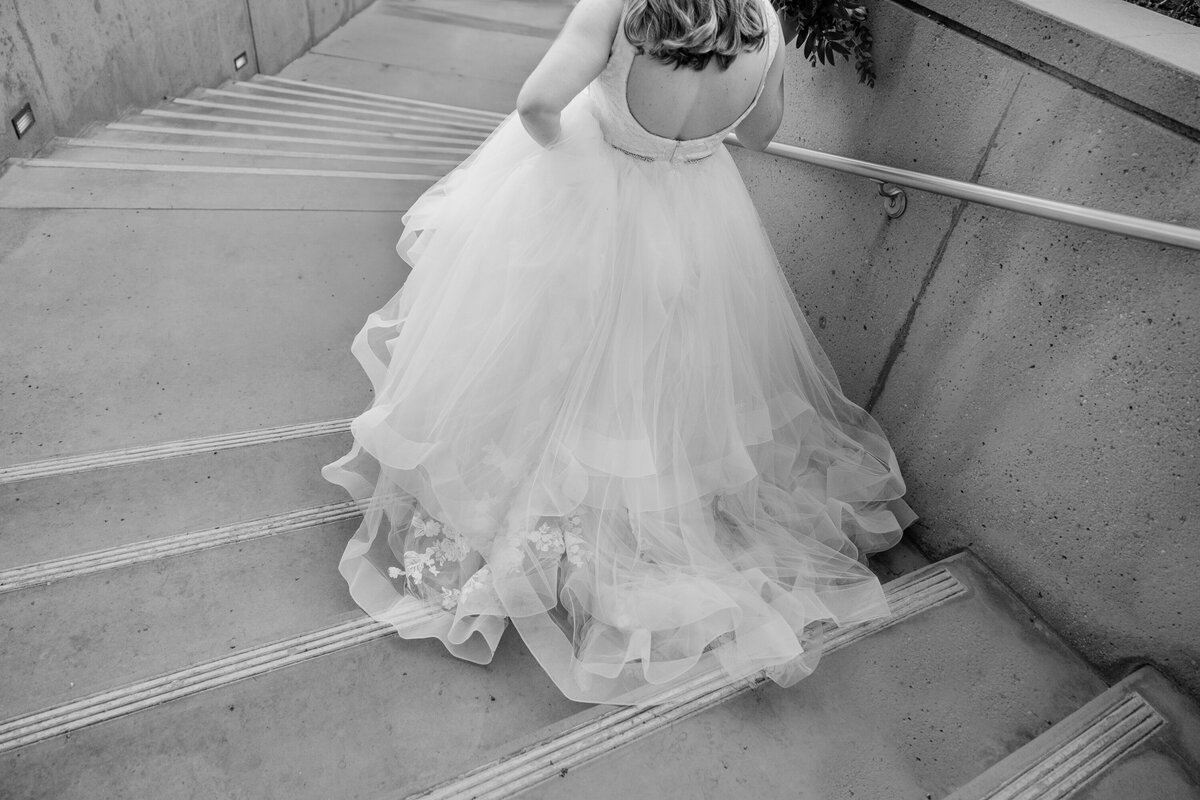 black and white image of bride walking down stairs at the nixon library