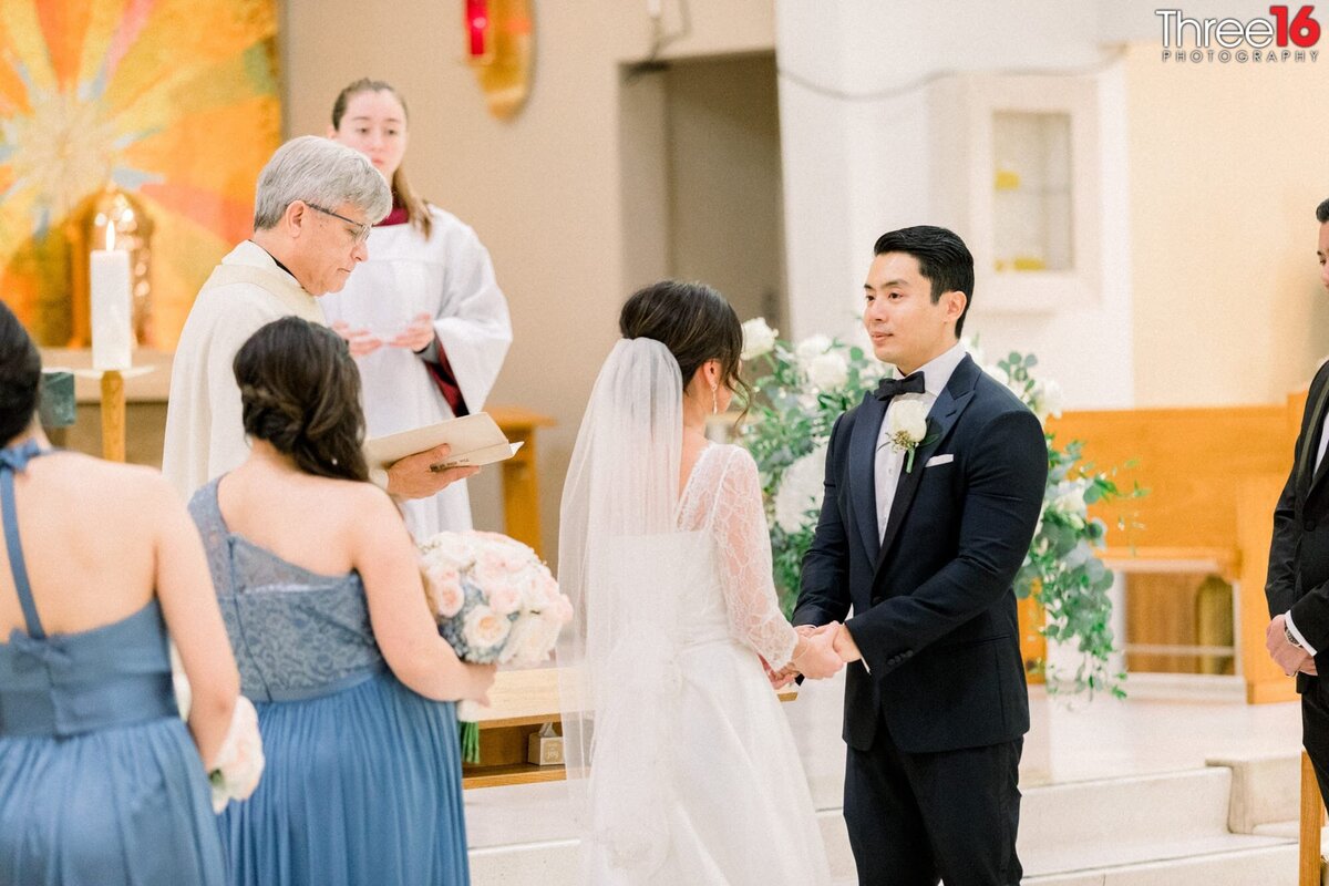 Bride and Groom face each other during a Catholic wedding ceremony