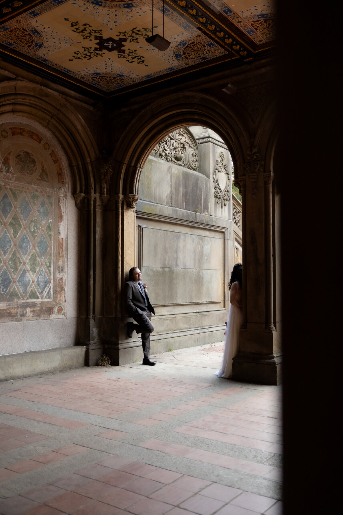 The couple sharing a tender moment beneath Central Park’s beautiful stone arches.