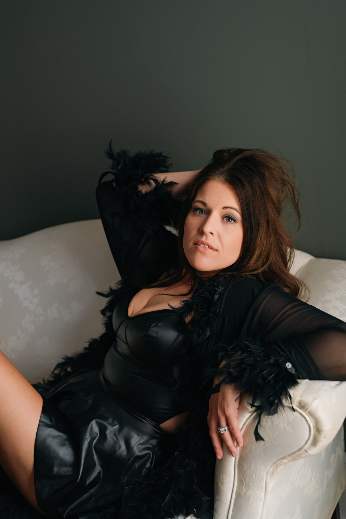 Lady with brown hair wearing a black robe with feathers for her boudoir session \ honey bacon boudoir