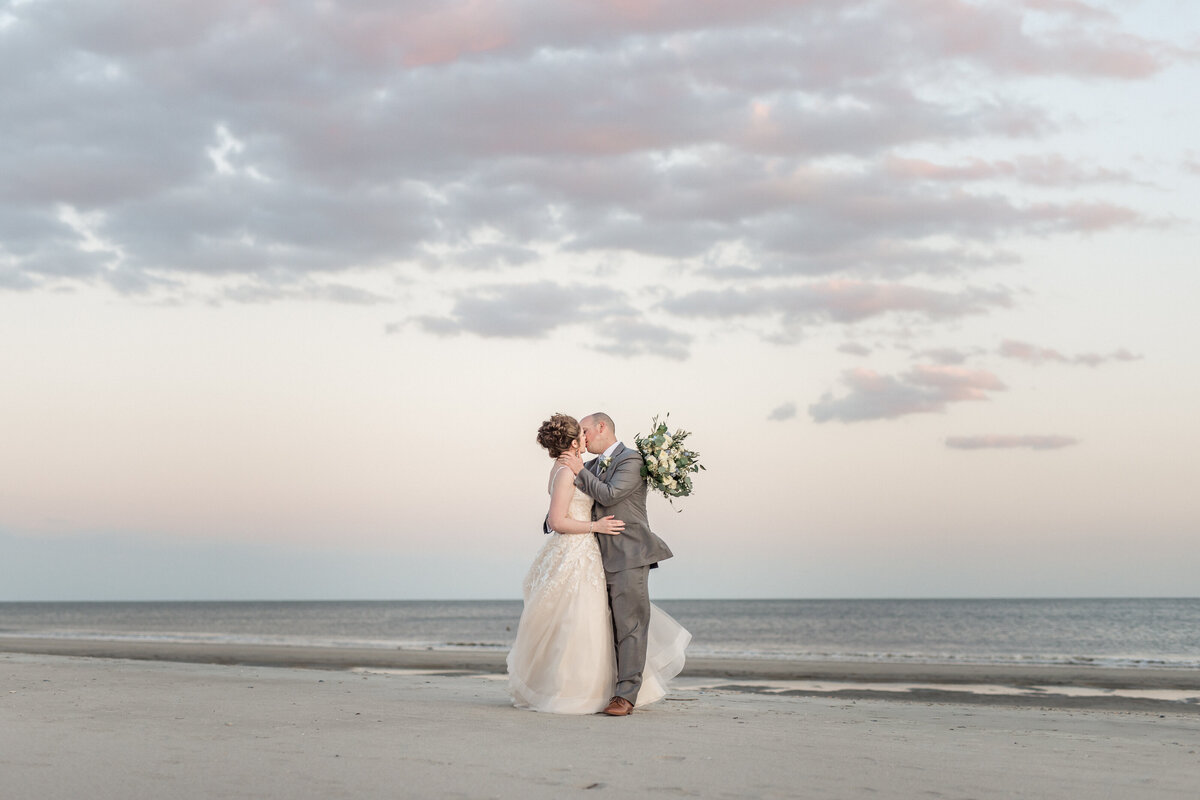 Bride and groom kiss on Folly Beach by Karen Schanely