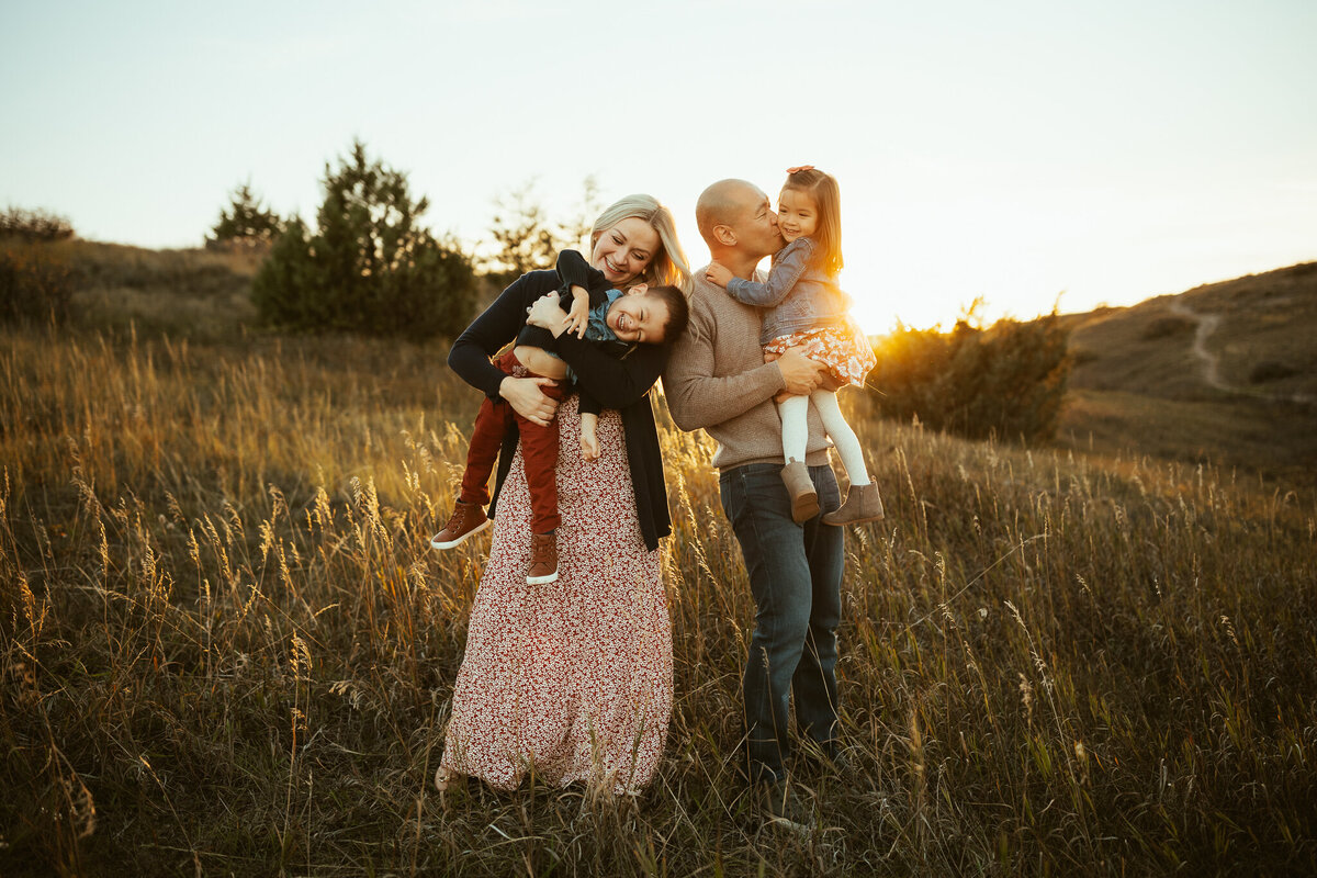 family having fun and loving each other in a hilly grassy landscape