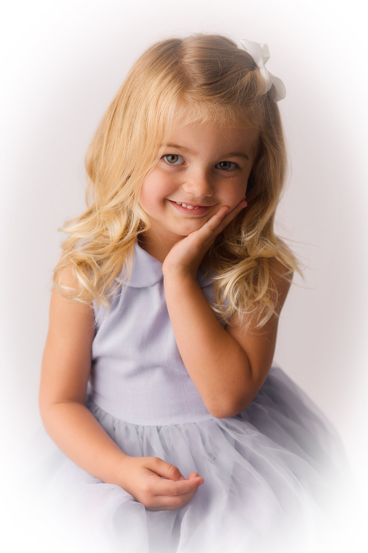 Little girl smiles into the camera during her Heirloom Portrait Photoshoot in Charleston, SC Portrait Studio.