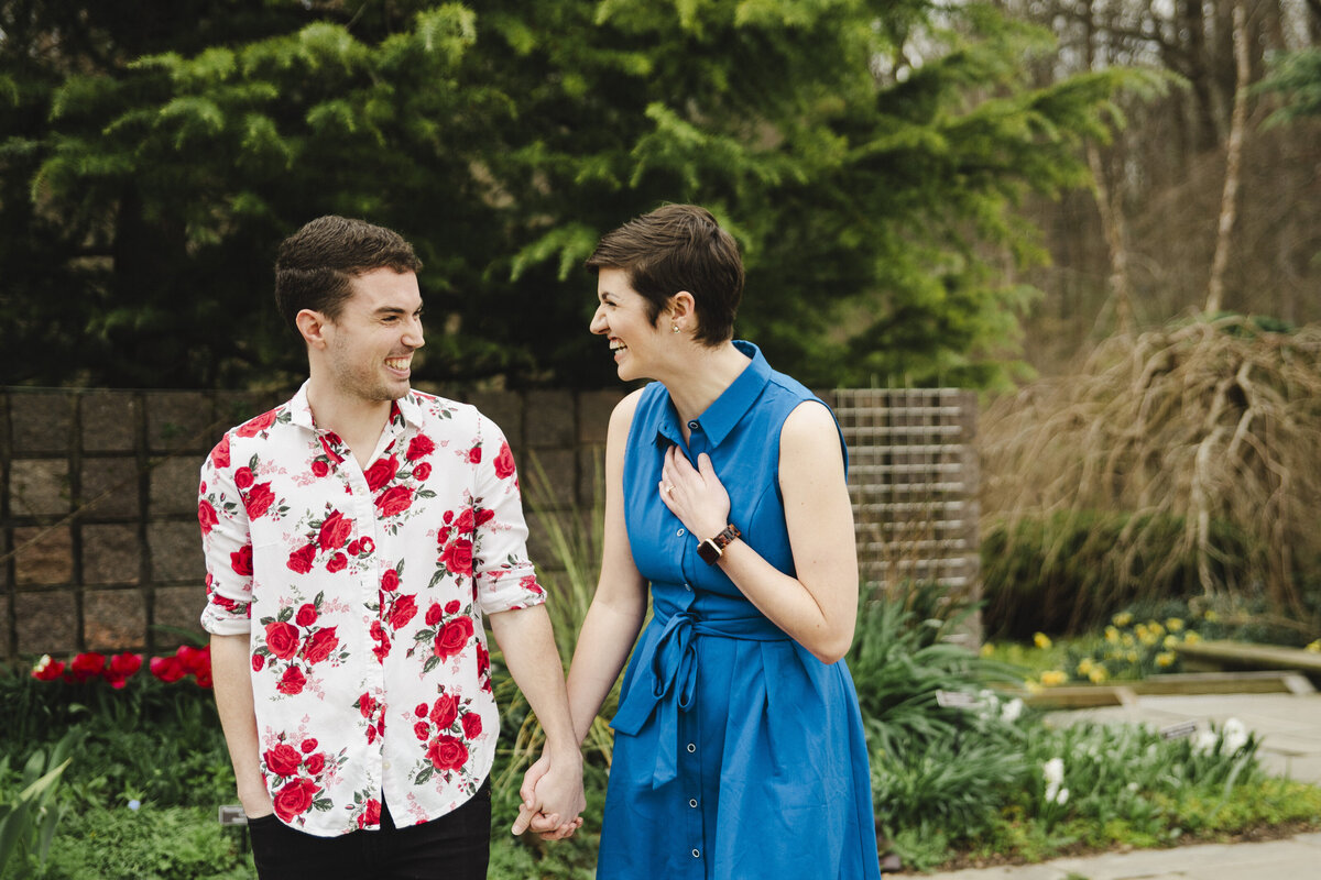 Two people hold hands while walking through Brookside Gardens.