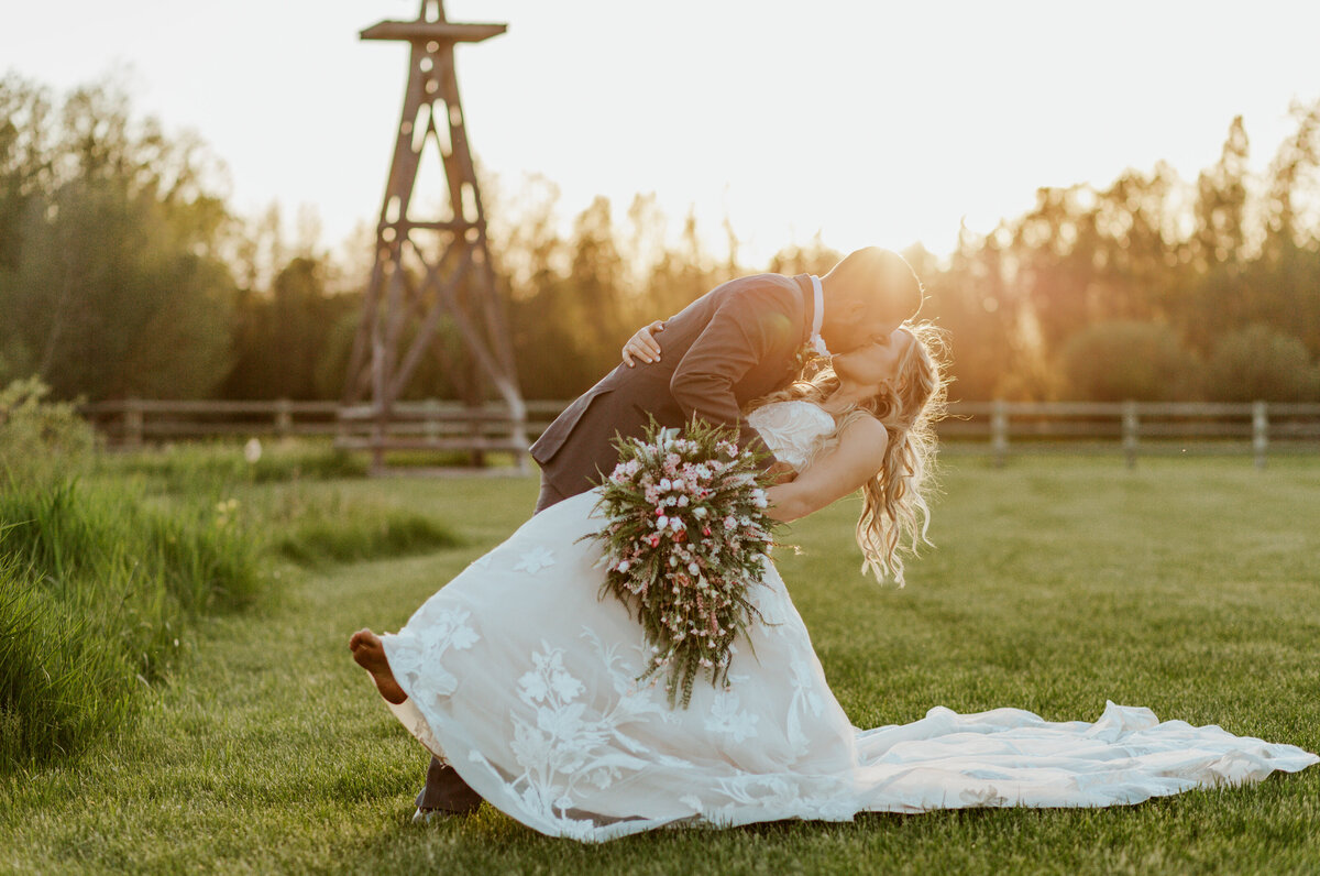 bride and groom kissing by windmill