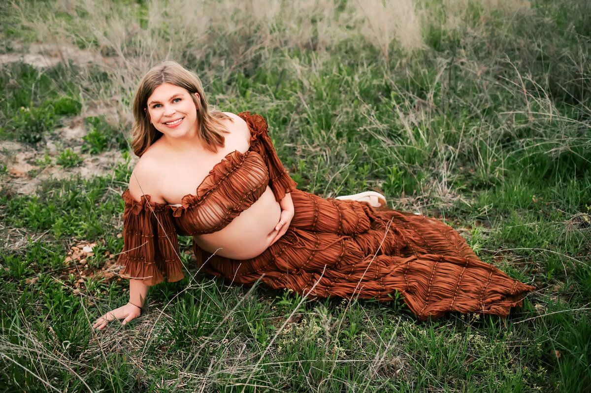 Springfield MO maternity photographer Jessica Kennedy of The XO Photography captures pregnant mom sitting on grass in a brown dress