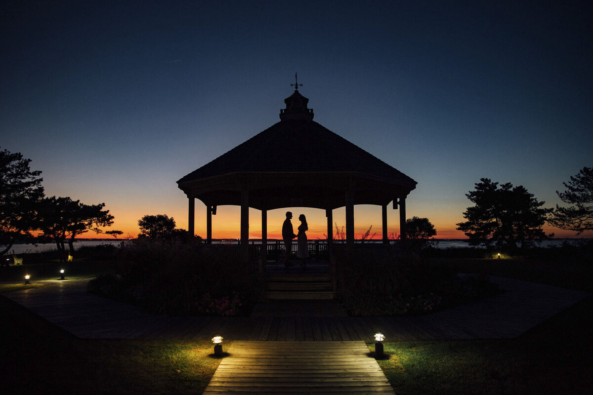 Couple in silhouette at sunset by gazebo during engagement photo in Point Pleasant New Jersey