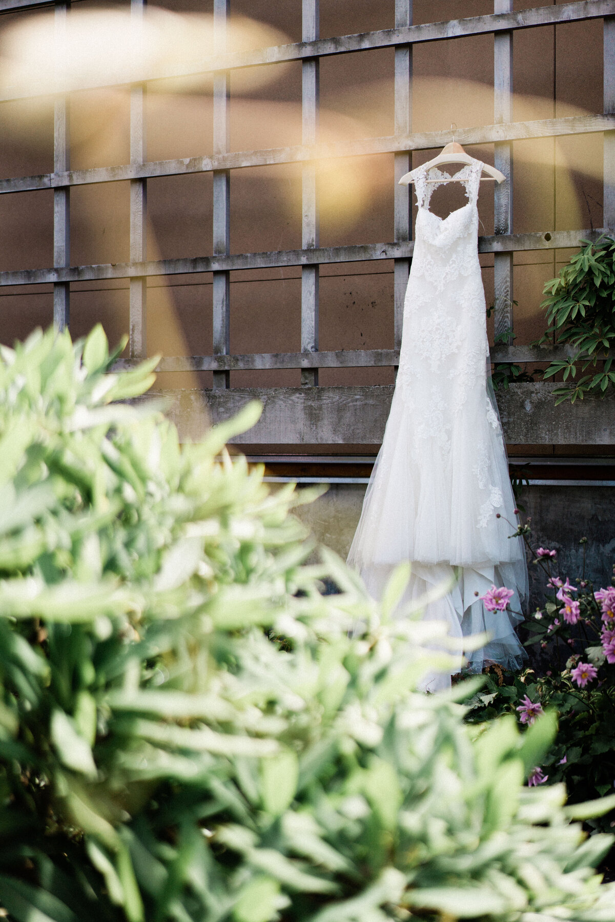 Bride's white dress hangs in the garden outside University of Washington Arboretum at Center for Urban Horticulture