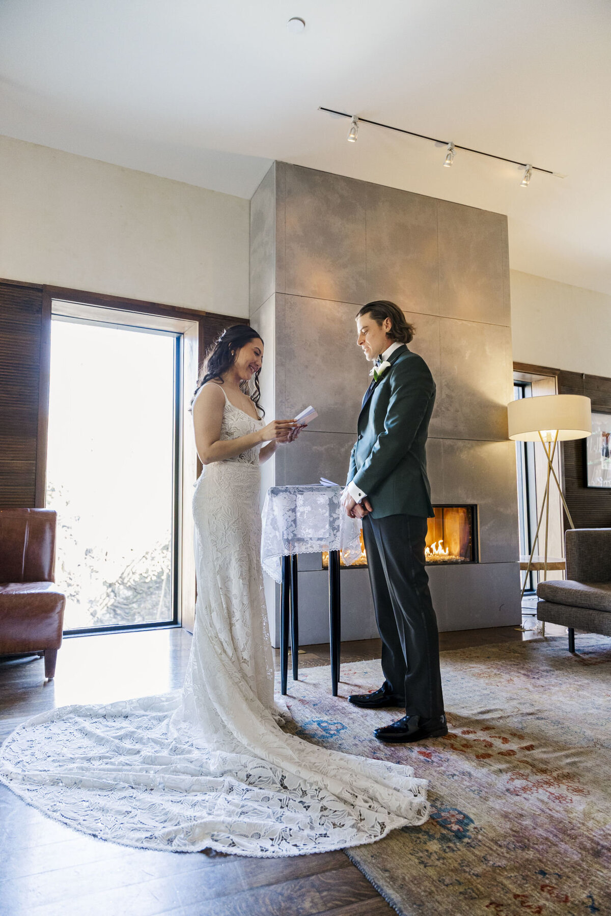 Bride and groom read their vows at The Lounge in The Roundhouse in front of the fireplace